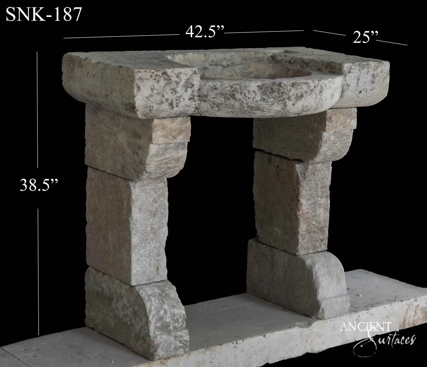 Reclaimed antique limestone console sink from Ancient Surfaces carved with ribbon tied festoon swags and a dark inset stone top, photographed against black